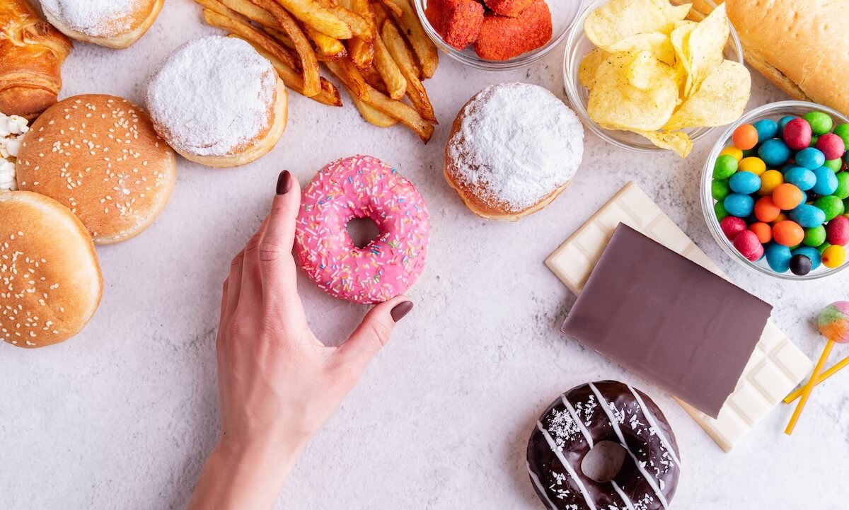 růžový podklad a na něm sladkosti a fast food